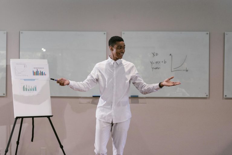 A confident man presenting a business report with graphs in a meeting room setting.